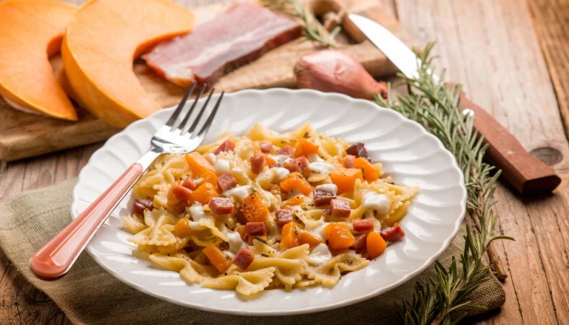 Farfalle con verdure e cubetti di bacon