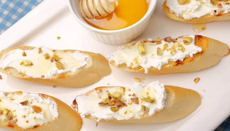 Crostoni al formaggio di capra con miele e pistacchi